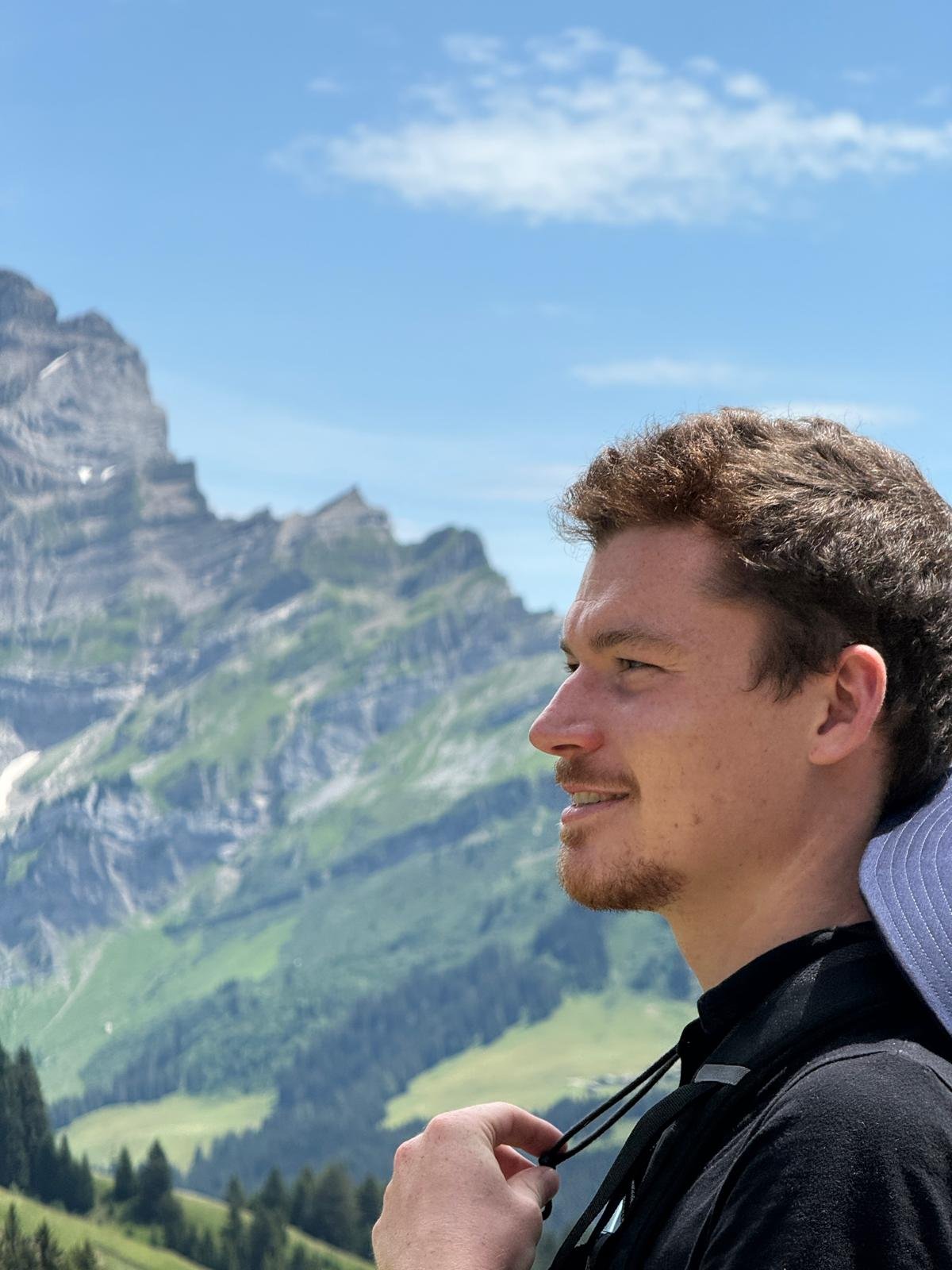Louis in profile in front of an alpine mountain