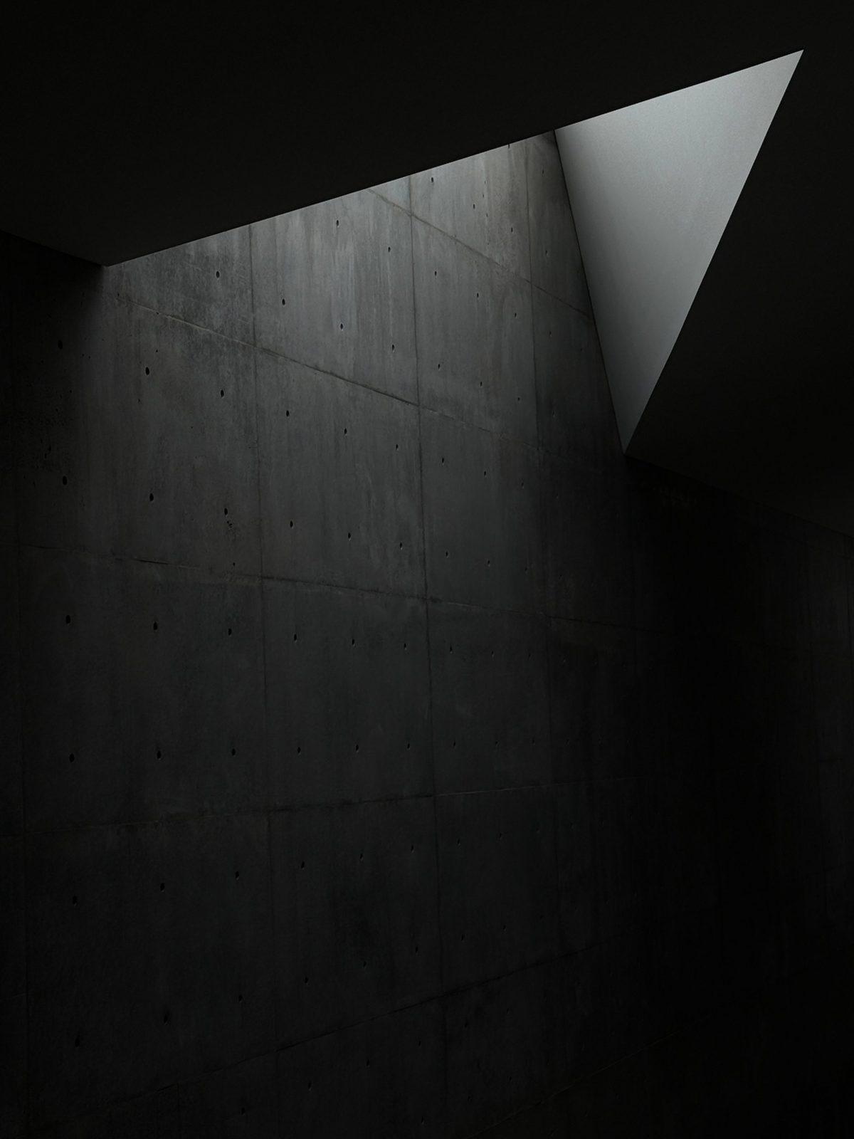 Dark concrete wall under a triangular skylight